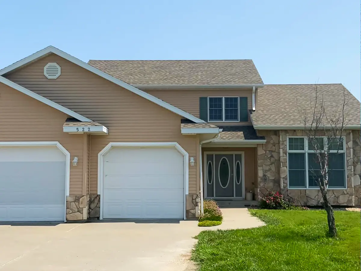 Suburban home under construction with visible roof damage and incomplete installation.