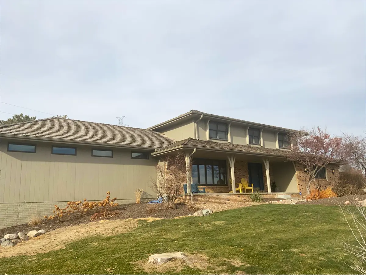 Suburban home under construction with visible roof damage and incomplete installation.