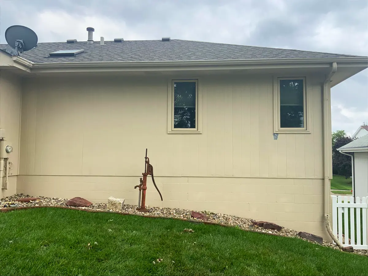 Single-story home with beige siding and visible wear, ready for siding replacement and updates.