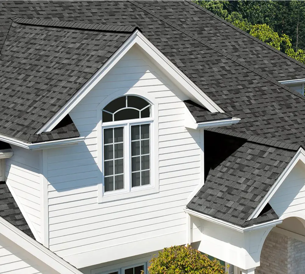 White home with a newly installed asphalt shingle roof, showcasing a modern and weather-resistant design.