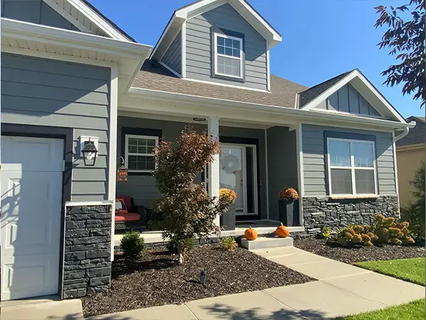 Beautifully finished home with updated gray siding and fresh landscaping after installation.