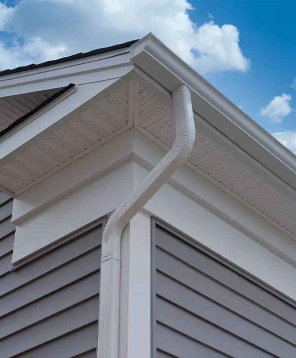 Fascia Board Replacement. White frame gutter guard system, with gray horizontal vinyl siding fascia, drip edge, soffit