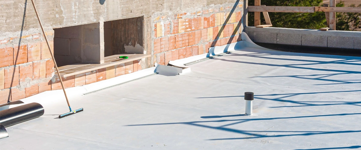 Worker applies pvc membrane roller on roof very carefully